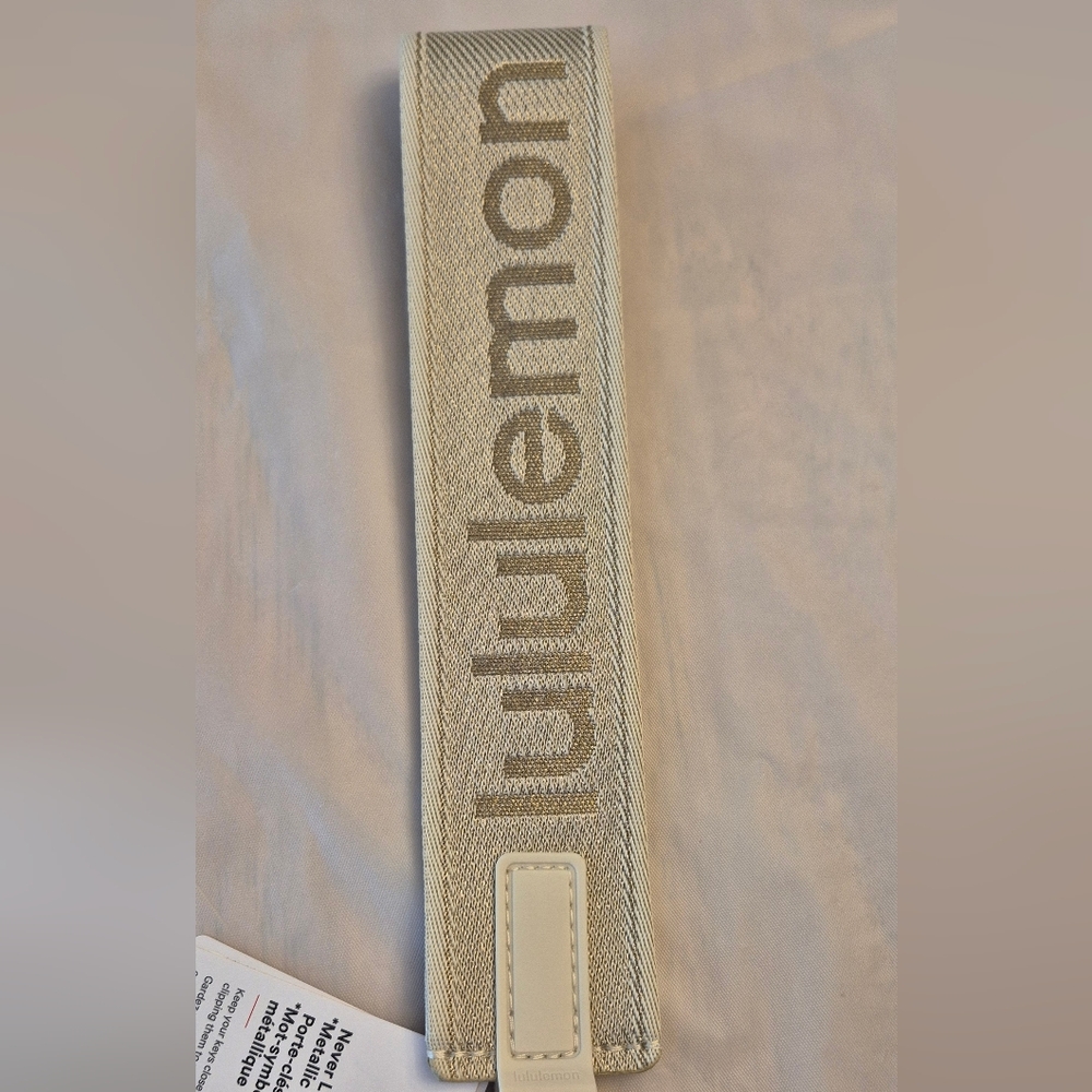 Lululemon Athletica Light Ivory Metallic Gold Wordmark Never Lost Keychain - Picture 3 of 4